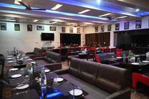 a dining room with tables and chairs and a stage at Kingfisher Resort in Dhanwār