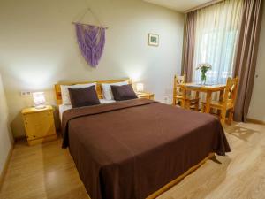 a bedroom with a large bed and a table with a table at Ecokayan Dilijan Resort Hotel in Dilijan