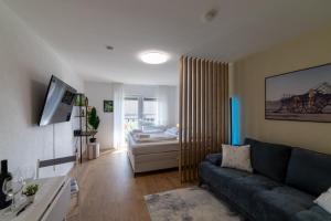 a living room with a couch and a bed at Lovely Nest - Goeppingen City, Kitchen, Parking, Up to 4 People in Göppingen