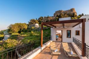 a house with a balcony with a view of a castle at Villa Lindos Muse in Lindos