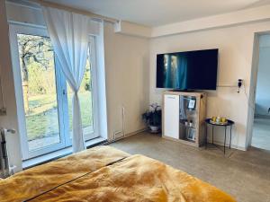 a bedroom with a bed and a flat screen tv at Apartment Schwarzwaldhöhen Pforzheim-Birkenfeld in Birkenfeld