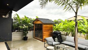 a small wooden shed sitting on top of a patio at Catalyst Retreat - Stylish, Pets, Accessible, Sauna in Coffs Harbour