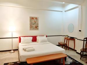 a bedroom with a white bed and a table at The Character Yaowarat MRT วัดมังกร in Bangkok