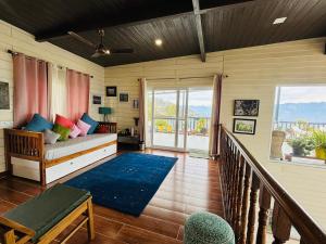 a living room with a bed and a balcony at The Ridge House Tehri in Chamba