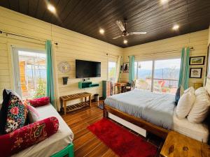 a bedroom with a bed and a tv and a couch at The Ridge House Tehri in Chamba