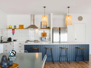 a kitchen with a blue counter and stools at Ultimate in Middleton Coastal Style with Views Sleeps 10 in Middleton