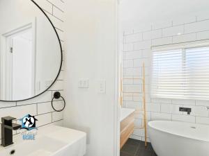 a bathroom with a mirror and a tub and a sink at Ultimate in Middleton Coastal Style with Views Sleeps 10 in Middleton +19 photos