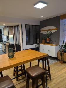 a kitchen and dining room with a wooden table and chairs at La promenade in Rennes