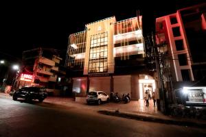 a city street at night with cars parked in front of buildings at G K Residency in Mangalore