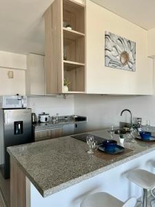 uma cozinha com armários brancos e uma bancada em Loft Ale Piso 22 em Lima