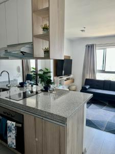 uma cozinha com bancada e uma sala de estar em Loft Ale Piso 22 em Lima