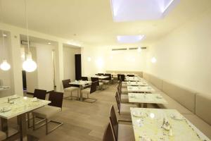 a dining room with tables and chairs and a skylight at Pure White in Prague