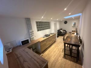 a kitchen and living room with a table and a couch at 2 chambres pour 6 pers proche plage et cap gris nez in Calais