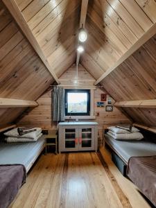a room with two beds and a tv in a cabin at Cudnie tu - Wdzydze in Wdzydze Kiszewskie