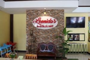 a sign for a restaurant on a brick wall at Leonida's Exclusive Resort in Talisay