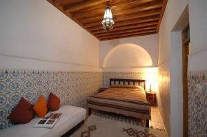 1 dormitorio con 2 camas y techo de madera en Riad El Sagaya, en Marrakech