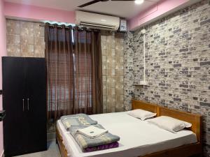 a bedroom with a bed and a brick wall at Hotel City Centre -Fooding and Lodging, Best Hotel in Itānagar +49 photos