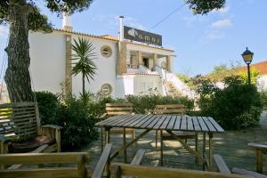 une table et des chaises devant une maison dans l'établissement Amar Hostel & Suites, à Ericeira