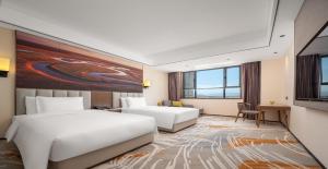 Postel nebo postele na pokoji v ubytování Wanda Jin Hotel Karamay Dushanzi Huiyang