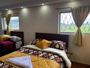 Un dormitorio con dos camas y dos ventanas. en INGEMEND, en San Gabriel
