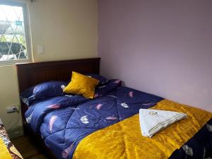 1 cama con edredón azul y almohadas amarillas en INGEMEND, en San Gabriel