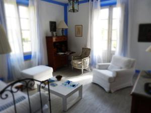 una sala de estar con muebles y ventanas blancos. en Bastide Rose, en Le Thor
