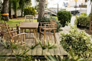 - une table et des chaises en bois dans le jardin dans l'établissement Amar Hostel & Suites, à Ericeira