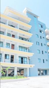 un edificio alto con un coche aparcado delante de él en Waterpark view apartment 1A, en Mombasa