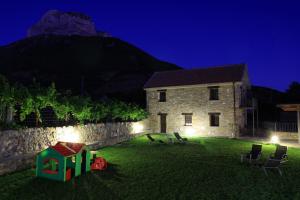 un bâtiment avec une cour avec une pièce de jeu installée dans l'herbe dans l'établissement Puerta de Ordesa Garden, à Laspuña