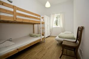 a bedroom with two bunk beds and a chair at Amar Hostel & Suites in Ericeira
