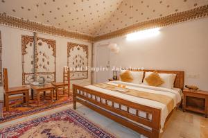 - une chambre avec un lit king-size et une table dans l'établissement Royal Empire Camp & Resort Jaisalmer, à Sām