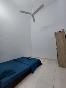 um quarto com uma cama azul e uma ventoinha de tecto em Sun Galaxy Homestay Jasin em Bemban