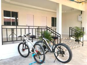 two bikes are parked in front of a building at Pin bupbha ปิ่นบุบผา in Ko Larn