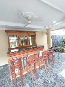 a kitchen with a bar with four chairs around it at Vila Sentul Private pool 6bedroom, 5bathroom, Privatepool tennis meja, Billiard, 0813delapannolsatuenam4151 in Gadok 1