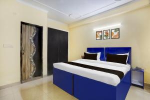 古尔冈Super Hotel O Sheetla Colony的客房内的一张蓝色和白色的床