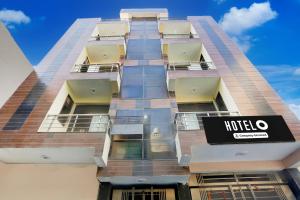古尔冈Super Hotel O Sheetla Colony的上面有酒店标志的高楼