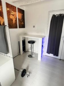 a room with a table and a stool next to a door at Grande Chambre Proximité Paris-Bondy 4 in Bondy +11 photos