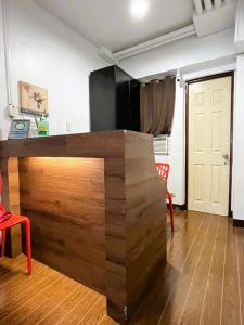 a wooden counter in a room with a red chair at BGC Suites EDSA Makati in Manila