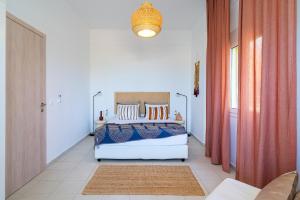 a bedroom with a white bed with blue and orange pillows at Coastal Key 6 in Gázion