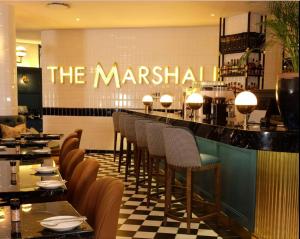 un restaurante con barra con mesas y sillas en City Haven 519, en Johannesburgo