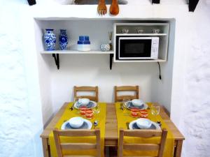 a small kitchen with a table and a microwave at Remédios, 195 in Lisbon