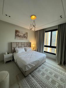 a bedroom with a bed and a large window at BEhouse, in Jeddah