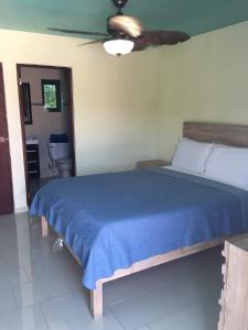 una camera da letto con un letto con una coperta blu di Mamacitas Guest House a Culebra