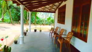 a group of chairs sitting on a patio at Sinharaja Green Villa Homestay in Deniyaya