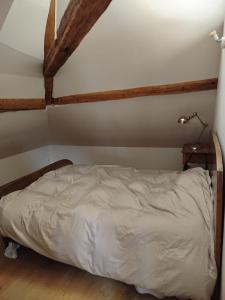 een bed in een kamer met houten balken bij Irène in Senlis +14 foto's