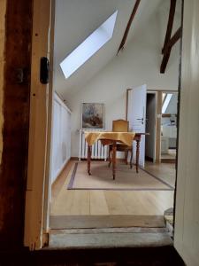 ein Dachzimmer mit einem Tisch und einem Schreibtisch in der Unterkunft Irène in Senlis