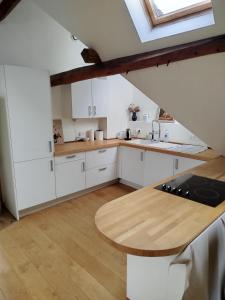 een keuken met witte kasten en een houten tafel bij Irène in Senlis