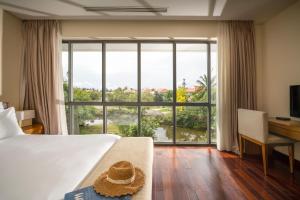 Una habitación de hotel con una cama y una ventana grande. en Villa Sân Vườn Lớn DN, en Da Nang