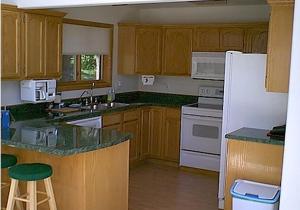 卡斯特的住宿－ThunderHeart，厨房配有木制橱柜和白色冰箱。