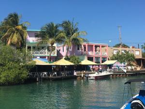 einen Yachthafen mit Tischen, Stühlen und Gebäuden auf dem Wasser in der Unterkunft Mamacitas Guest House in Culebra